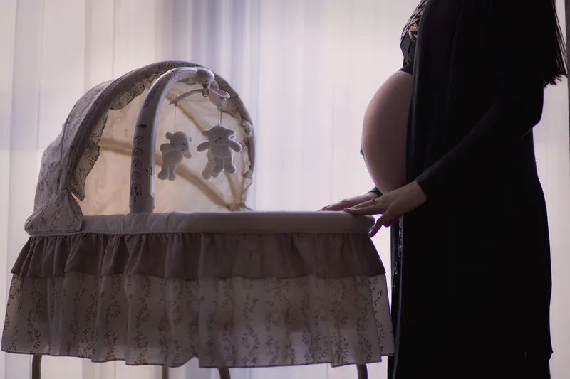 Pregnant woman preparing baby nursery